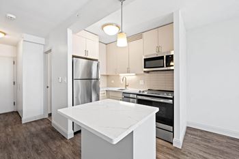 A kitchen with a white island and stainless steel appliances.